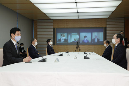 月例経済報告等に関する関係閣僚会議に臨む菅義偉首相（左から２人目）。左端は西村康稔経済財政担当相＝２２日午後、首相官邸