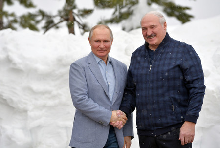 22日、ロシア南部ソチで、握手するロシアのプーチン大統領(左)とベラルーシのルカシェンコ大統領(EPA時事)