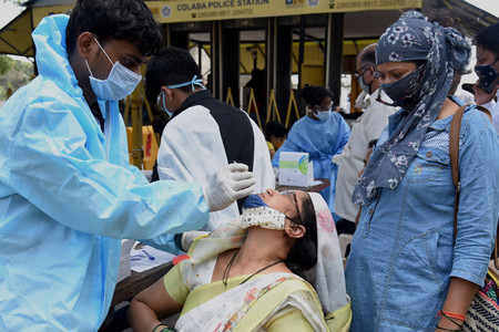 繁華街に設けられた会場で、義務化された新型コロナウイルス検査を受けるインド市民＝３日、ムンバイ（ＡＦＰ時事）