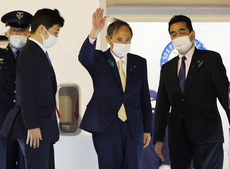 日米首脳会談のため、米国へ出発する菅義偉首相（右から２人目）＝１５日夜、羽田空港