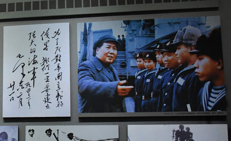 中国人民解放軍海軍誕生地記念館に展示されている毛沢東の海軍視察写真と「強大な海軍」の筆跡＝９日、江蘇省泰州市