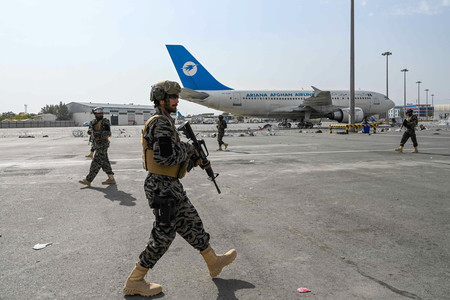 ３１日、米軍が撤収したカブールの空港で、警備に当たるタリバン戦闘員（ＡＦＰ時事）