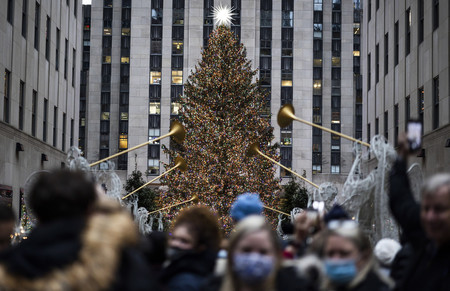 ２日、米ニューヨークの複合商業施設ロックフェラーセンターのクリスマスツリーを見ようと集まる人々（ＥＰＡ時事）