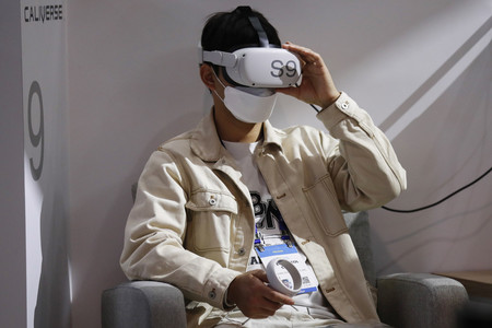 仮想空間を体験できる仮想現実(VR)ゴーグルを着用する人=5日、米ラスベガス(EPA時事)