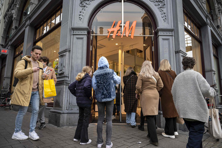 １５日、オランダ・アムステルダムで、新型コロナウイルス規制の緩和で再開された衣料品店に入る買い物客（ＡＦＰ時事）