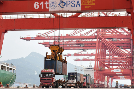 港でトラックにコンテナが積まれる様子＝２０２１年９月、中国・江蘇省（ＡＦＰ時事）