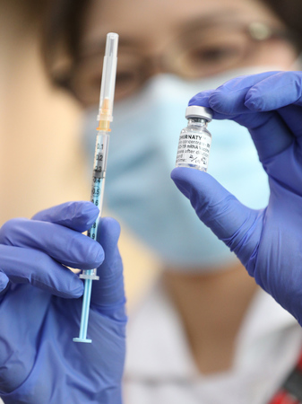 新型コロナウイルスワクチンが吸引された注射器（左）とワクチンの入った瓶＝２０２１年２月１９日、大阪府豊中市の大阪刀根山医療センター