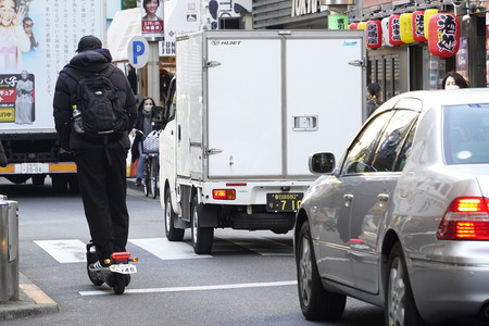 街中を走る電動キックスケーター＝２月２日、東京都渋谷区