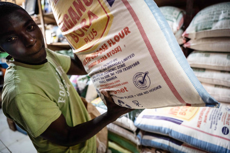 ルワンダ首都キガリの店舗で小麦粉の袋を持つ男性＝３月２３日（ＡＦＰ時事）