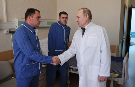 ２５日、モスクワの軍病院で、ウクライナで負傷した兵士を見舞うロシアのプーチン大統領（ＡＦＰ時事）