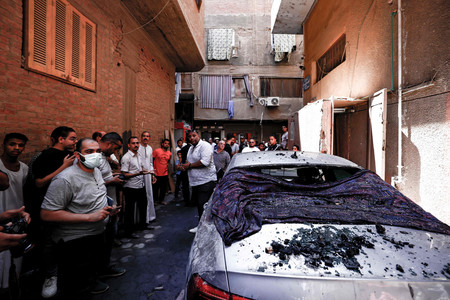 １４日、カイロ近郊ギザの教会火災現場に集まるエジプトの人々（ＡＦＰ時事）