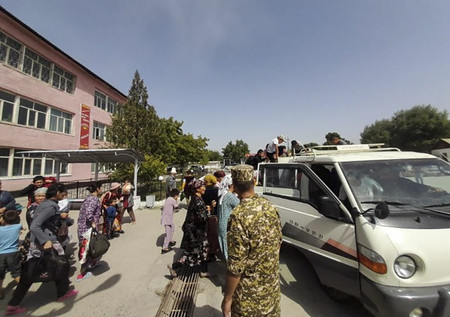 １７日、キルギス南西部バトケン州で、戦闘から逃れるため避難用のバスに駆け込む人々（キルギス政府提供）（ＥＰＡ時事）