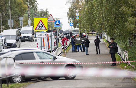 26日、ロシア中部イジェフスクの銃撃事件現場付近に出動した警官や救急隊員ら(EPA時事)