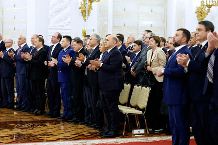 30日、モスクワのクレムリン(ロシア大統領府)で、「編入条約」調印の式典で拍手する議員ら(ロイター時事)