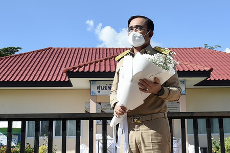 ７日、タイ東北部ノンブアランプー県で、花を供えるため、銃乱射事件が起きた保育所を訪れるプラユット首相（タイ政府提供）