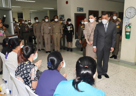 ７日、タイ東北部ノンブアランプー県で、銃乱射事件の被害者家族を慰問するワチラロンコン国王（右）と王妃（タイ王室事務局提供・時事）