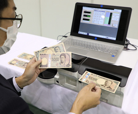 報道公開された、デモ機による新紙幣の読み取り検査＝２１日午前、東京都北区
