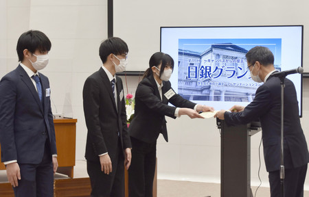 「日銀グランプリ」で、若田部昌澄日銀副総裁(右)から表彰状を受け取る東京経済大学の学生ら=23日午後、東京都中央区
