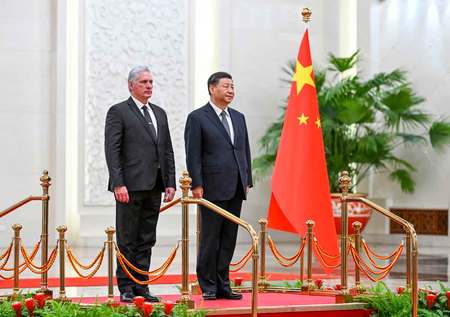25日、中国・北京の人民大会堂での会談に先立つ歓迎式典で、キューバのディアスカネル大統領(左)と並ぶ習近平国家主席(EPA時事)