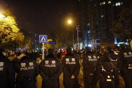 ２７日、中国・北京市で、抗議活動に対し通りを封鎖する警察官（ＥＰＡ時事）