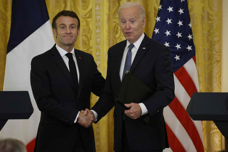 １日、ワシントンのホワイトハウスで、共同記者会見後に握手を交わすバイデン米大統領（右）とフランスのマクロン大統領（ＡＦＰ時事）