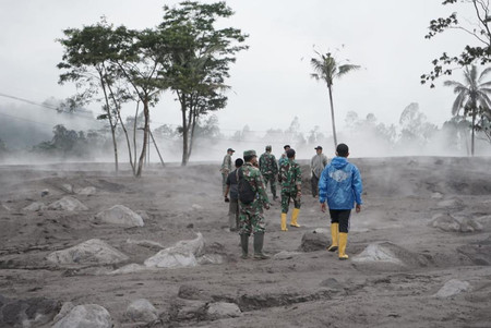 ４日、インドネシアのスメル山が噴火し、降り積もった灰の中を歩く東ジャワ州の人々＝住民のツイッターから