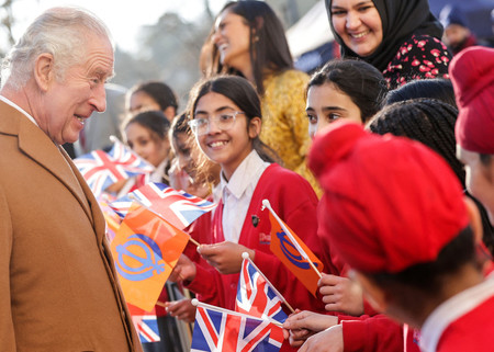 ６日、ロンドン北方のルートンを訪れ子供と交流するチャールズ英国王（左）（ＡＦＰ時事）