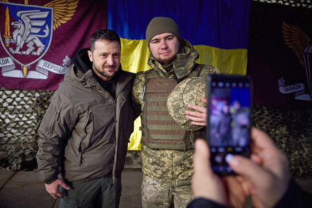 ６日、ウクライナ東部スラビャンスクを訪れ、兵士と写真を撮るゼレンスキー大統領（左）＝ウクライナ大統領府提供（ＥＰＡ時事）