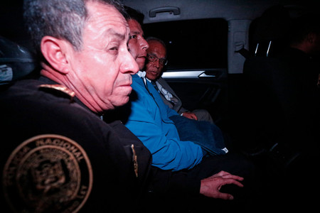 ７日、ペルーの首都リマで、警察車両に乗るカスティジョ前大統領（中央）（ＡＦＰ時事）