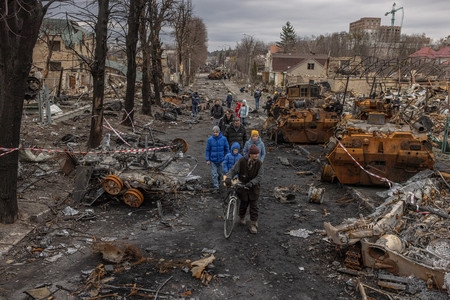 破壊されたウクライナ北部ブチャの通りを歩く住民ら＝４月６日（ＥＰＡ時事）