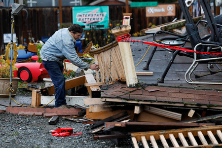２０日、米カリフォルニア州北部で、自宅の地震被害を調べる男性（ロイター時事）