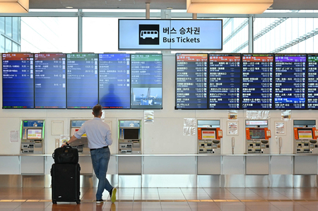 東京・羽田空港の国際線ターミナルで、バスの時刻表を見る外国人男性＝１０月１１日（ＡＦＰ時事）
