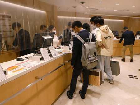 松屋銀座の免税カウンターで手続きをする訪日外国人旅行者ら＝２０２２年１０月１８日、東京都中央区