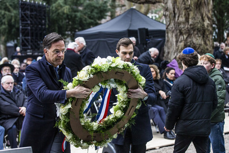 ２９日、アムステルダムで、ホロコースト追悼イベントで花輪をささげるオランダのルッテ首相（左）（ＡＦＰ時事）