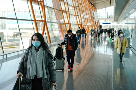 北京の国際空港でマスクを着けて歩く人々＝１月２８日、北京（ＥＰＡ時事）