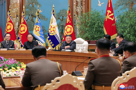 ６日、北朝鮮の平壌で行われた朝鮮労働党中央軍事委員会の拡大会議に出席する金正恩党総書記（中央）（朝鮮通信・時事）