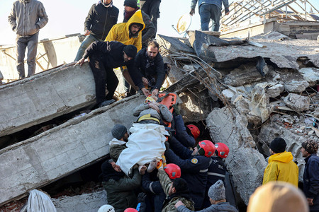 ７日、トルコ南部カフラマンマラシュ県で、地震によって倒壊した建物から生存者を救助する人々（ＡＦＰ時事）