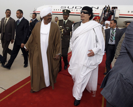 ２０１０年３月、リビア中部シルトに到着したカダフィ大佐（右）とスーダンのバシル大統領（左、いずれも当時）（ＥＰＡ時事）