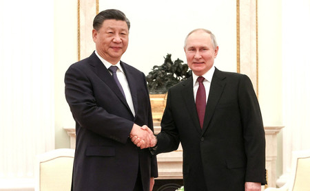 ２０日、モスクワで会談し、握手をする中国の習近平国家主席（左）とロシアのプーチン大統領（ロイター時事）