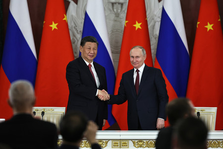 ２１日、モスクワで、共同声明の署名式に臨み握手する中国の習近平国家主席（左）とロシアのプーチン大統領（ＥＰＡ時事）