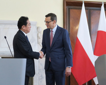 ２２日、ワルシャワで、共同記者発表に臨み握手する岸田文雄首相（左）とポーランドのモラウィエツキ首相