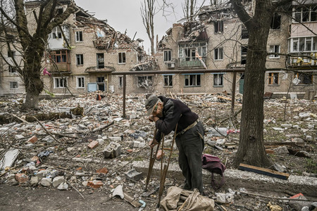 がれきの中から木材を拾う高齢者＝１８日、ウクライナ東部ドネツク州アウディイウカ（ＡＦＰ時事）