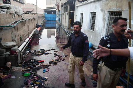 ３１日、パキスタン南部カラチで、食料配給を求める人々が殺到した事故現場（ＡＦＰ時事）