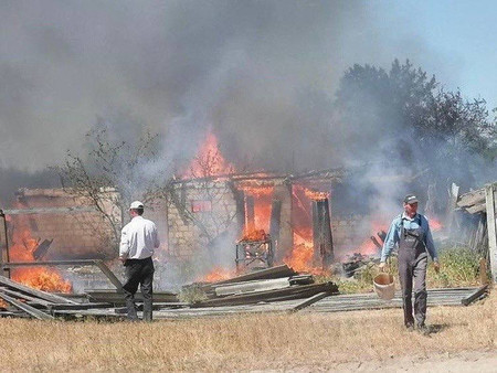 ２９日、ウクライナ北部キーウ（キエフ）州で、ロシア軍のミサイル攻撃で炎上する家屋（ロイター時事）