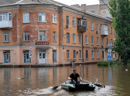 ８日、ウクライナ南部ヘルソン州で、ダム決壊で浸水し、ボートで避難する住民（ＡＦＰ時事）