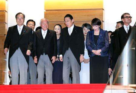 笑顔で記念撮影に向かう岸田文雄首相（中央）＝１３日午後、首相官邸