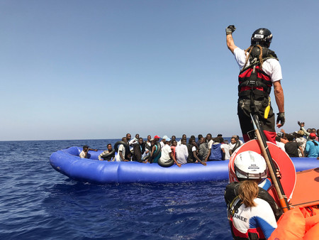 移民を乗せたゴムボートの救助活動に当たる国際ＮＧＯ「ＳＯＳメディテラネ」の救助船の乗組員ら＝２０１９年８月、地中海（ＡＦＰ時事）