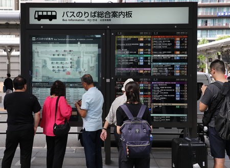 京都駅前のバス乗り場で、案内板を見る観光客ら＝京都市下京区