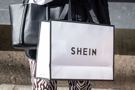 「ＳＨＥＩＮ（シーイン）」のショッピングバッグを持つ女性＝２０２２年１１月、東京都渋谷区（ＡＦＰ時事）
