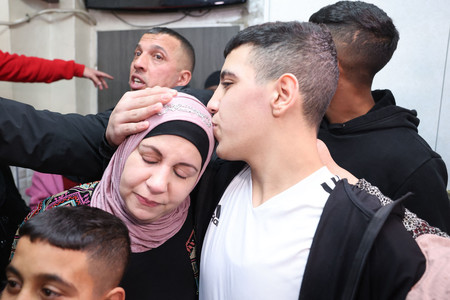 ２８日、釈放されて東エルサレムの自宅で母親に迎えられるパレスチナ人男性（中央右）（ＡＦＰ時事）
